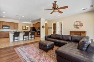 a living room with a leather couch and a ceiling fan at Grand Ironhorse in Queen Creek +38 photos