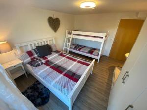 a bedroom with two bunk beds and a desk at Große Ferienwohnung am Badesee in Erzgrube
