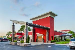 een rood gebouw met een auto geparkeerd op een parkeerplaats bij Days Inn & Suites by Wyndham Johnson City in Johnson City