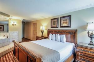 a bedroom with a large bed and a bathroom at Days Inn & Suites by Wyndham Johnson City in Johnson City