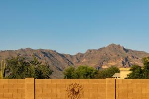 a wall with a sun painted on it with mountains in the background at Honeysuckle Oasis in Gold Canyon