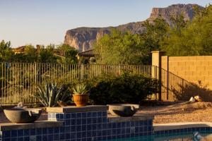 a pool with a fence and some plants in a yard at Honeysuckle Oasis in Gold Canyon