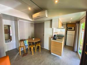 a small kitchen and dining room with a table and chairs at Camping Alicante Imperium in Villajoyosa