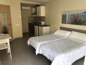Habitación de hotel con 2 camas y cocina en Apartamentos Turisticos Maria Guerrero en Cabo de Palos