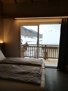 ein Schlafzimmer mit einem Bett und einem großen Fenster in der Unterkunft Garni Al Silvestri Vei in Livigno