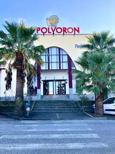 a building with palm trees in front of it at Don Polvorón in Estepa