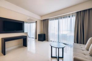a living room with a couch and a tv and a table at Iberostar Selection Kuriat Palace in Monastir