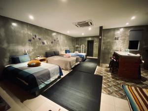 a hotel room with two beds and a desk at Ipoh Zing Vale - Family & Couple Suite in Ipoh