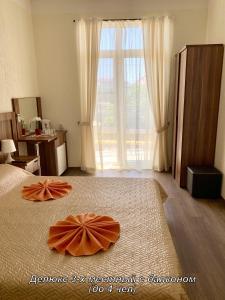 ヴィチャゼヴォにあるMirada Guest Houseのベッドルーム1室(ベッドにオレンジの枕2つ付)