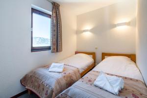 En eller flere senge i et værelse på Vacancéole - Résidence Grand Morillon