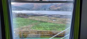 a view of a lake from a window at 2 CV at Lochgoilhead with Swedish Hot Tub in Lochgoilhead