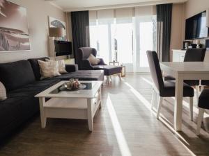 a living room with a couch and a table at Beachcomber House A in Friedrichskoog
