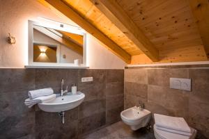 a bathroom with a sink and a toilet and a mirror at Ferienwohnung Hofmann in Kiefersfelden +10 photos