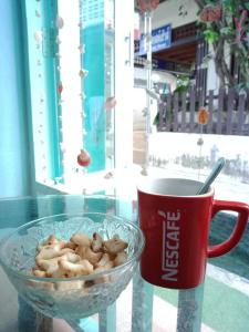a glass table with a bowl of food and a cup of coffee at Sea Shell Hut in Phi Phi Don