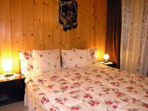 a bedroom with a large bed with flowers on it at Hotel Vesta in Kazanlŭk