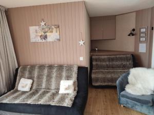 un salon avec un canapé et une chaise dans l'établissement LE COSY aux pieds des pistes appartement avec balcon PLEIN CENTRE, à Orcières