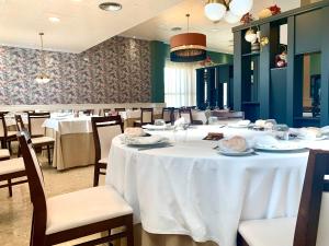 una sala da pranzo con tavolo e sedie bianchi di Don Polvorón a Estepa
