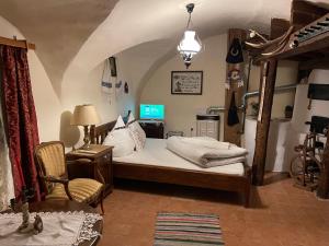 a bedroom with a bed and a chair and a tv at Casa Morar in Sighişoara