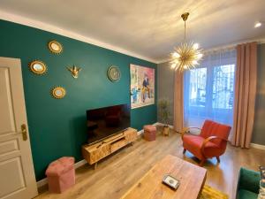 una sala de estar con una pared verde y una mesa. en Apartament Golden Art en Mielec