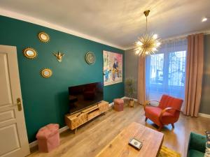a living room with a green wall with a table at Apartament Golden Art in Mielec +4 photos