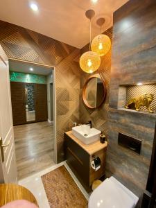 y baño con lavabo y espejo. en Apartament Golden Art en Mielec