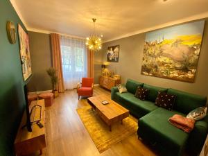 sala de estar con sofá verde y mesa en Apartament Golden Art en Mielec