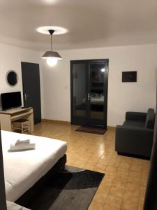 Habitación con cama, sofá y escritorio. en Appartement LOGIS DES MARAIS, en Saint-Philbert-de-Grand-Lieu