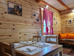a dining room with a table and chairs in a cabin at Guest House Rankić in Mokra Gora