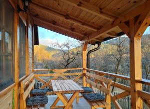 a wooden porch with a table and chairs on it at Guest House Rankić in Mokra Gora