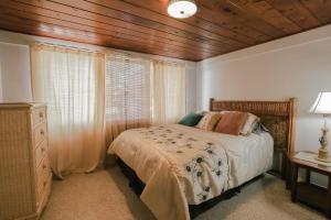 ein Schlafzimmer mit einem Bett und einer Holzdecke in der Unterkunft Siesta Vacation Home in Venice