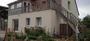 a house with a balcony on the side of it at Le Repos des Crins Noirs in Esson