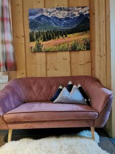 a purple couch with pillows on it in a room at Podhalańska Chatka in Zakopane