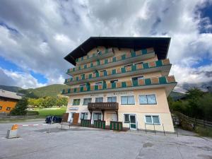 a tall building in a parking lot with a sky at Dachsteinblick apartment in Ramsau am Dachstein
