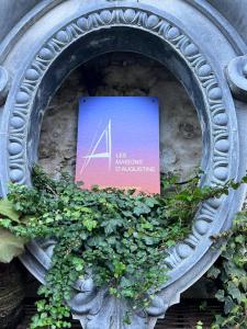 a sign on the side of a building with plants at Les Maisons d'Augustine, nouvelle demeure de la cour Ste Catherine in Honfleur