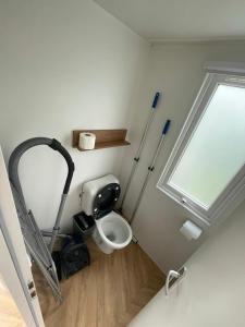 a small bathroom with a toilet and a window at Renesse Chalet in family friendly area in Renesse