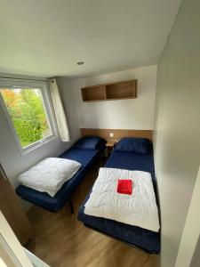 Habitación pequeña con 2 camas y ventana en Renesse Chalet in family friendly area en Renesse
