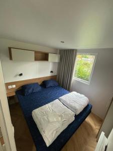 a small bedroom with a bed and a window at Renesse Chalet in family friendly area in Renesse