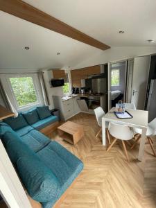 a living room with a blue couch and a table at Renesse Chalet in family friendly area in Renesse