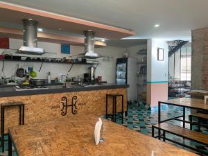 a large kitchen with a counter and tables at Hostal Hidalgo in Guadalajara