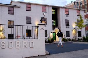 a man walks in front of a hotel at SoBro Guest House by Black Swan in Nashville