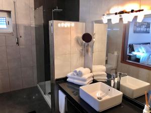 a bathroom with a sink and a shower and a mirror at HOTEL BOUTIQUE a ESPLANADA in Castelo Branco