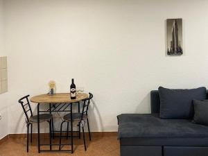 a table with a bottle of wine on it next to a couch at Apartman City in Livno