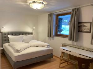 a bedroom with a bed with white pillows and a window at Appartementhaus Grocke in Wagrain