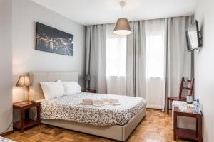 a bedroom with a bed and a dresser at Oporto Santa Catarina Residence in Porto