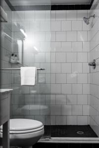 a white tiled bathroom with a toilet and a shower at The Sobro Guest House by AvantStay in Nashville
