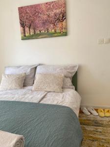 a bedroom with a bed with a painting on the wall at Enni Guest House in Mostar