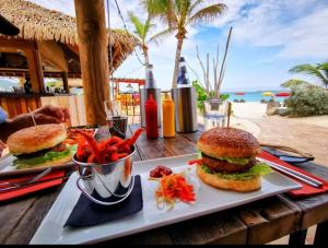 a plate with two hamburgers and a bowl of food at Esmeralda Resort in Orient Bay