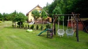 - une aire de jeux dans la cour d'une maison dans l'établissement Dom nad stawem, à Żywki