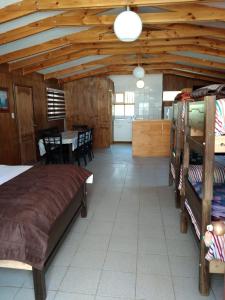a bedroom with a large bed and a dining room at Apartamentos y Cabañas el Caleuche El Tabo in El Tabo