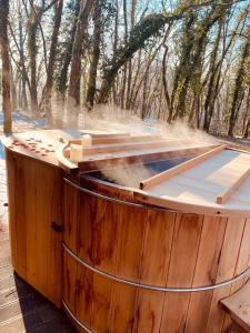 Un grand tonneau en bois avec de la fumée qui en sort dans l'établissement Le Bois Dormant-Hôtel Restaurant & Spa Logis Hôtel, à Champagnole